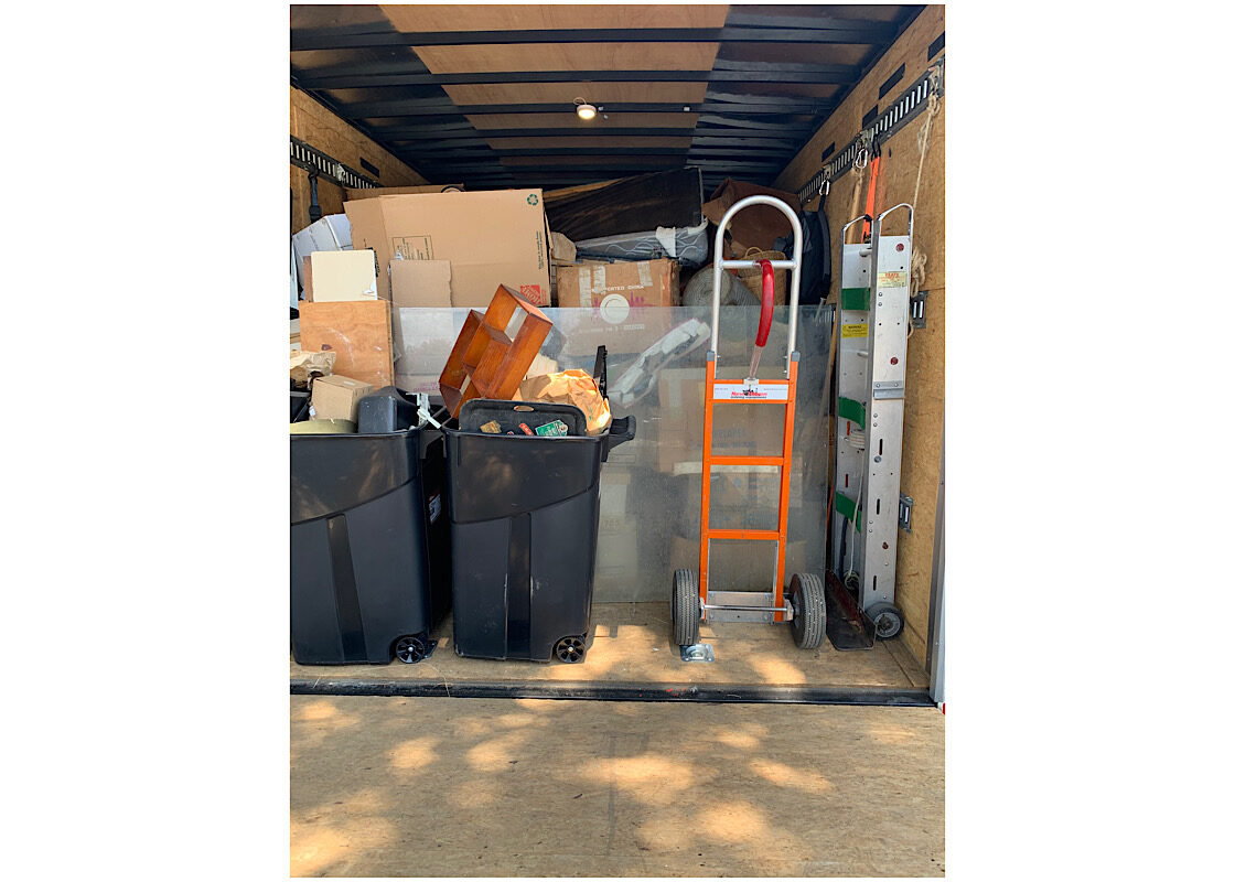 Organized Dallas Junk Removal Truck Interior view of a Dependable Guy truck organized with boxes, storage bins, and a moving dolly for a Dallas junk removal job