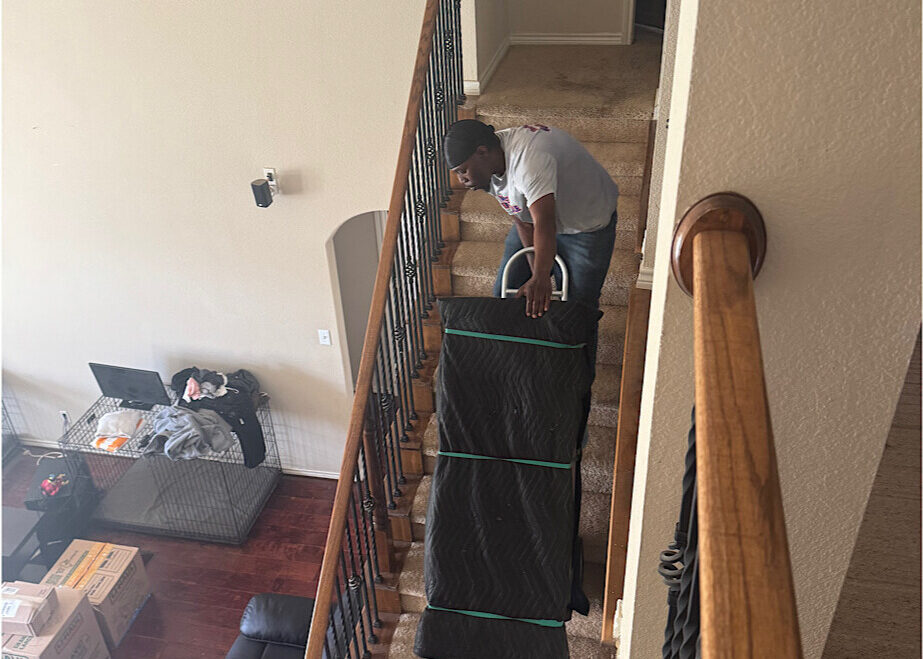 mover-carrying-furniture-upstairs A mover carrying wrapped furniture up a flight of stairs